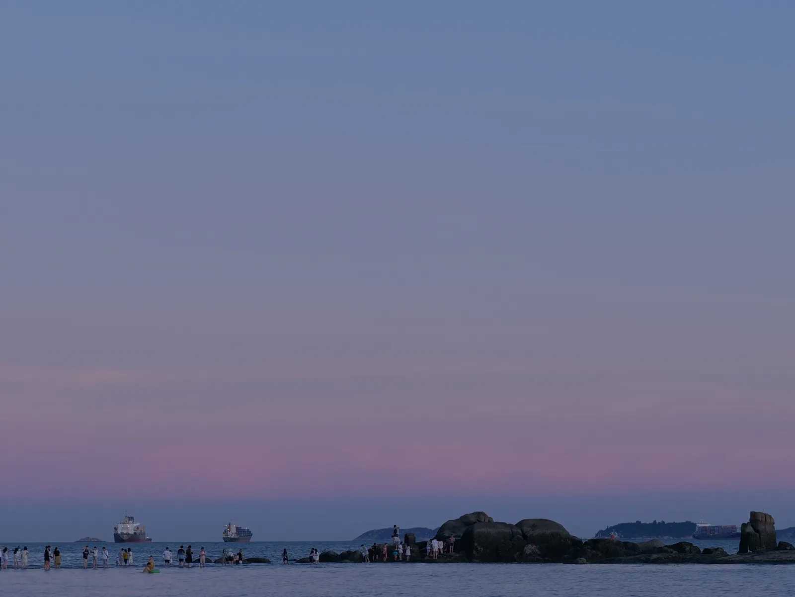 A quiet shoreline beneath a violet blue-hour sky