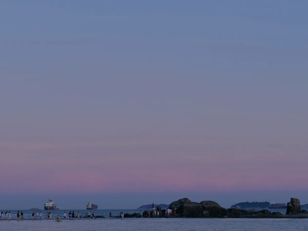 A quiet shoreline beneath a violet blue-hour sky