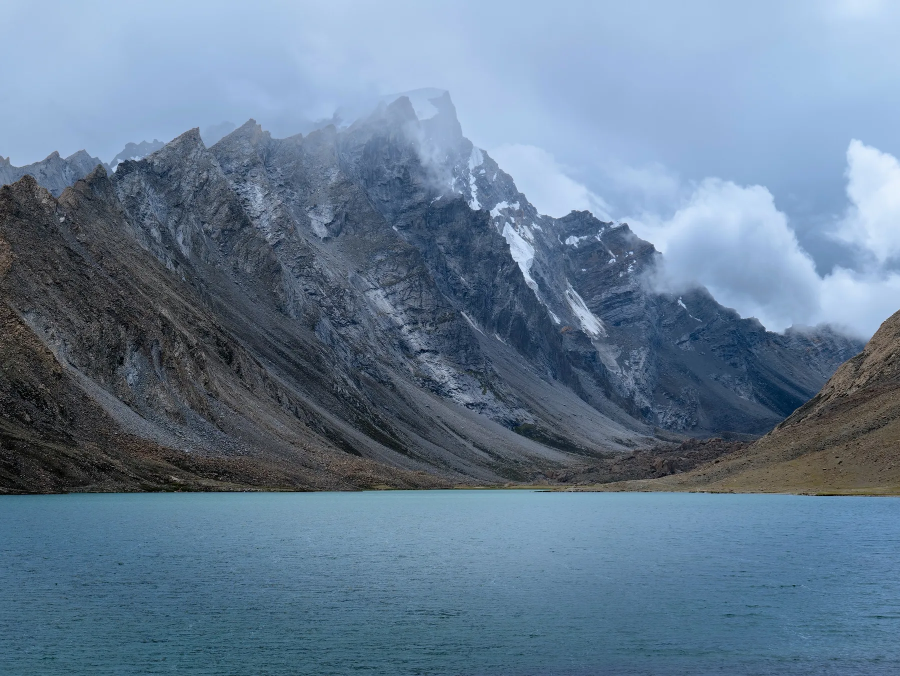 Jagged mountain peaks rising beyond the blue edge of a lake