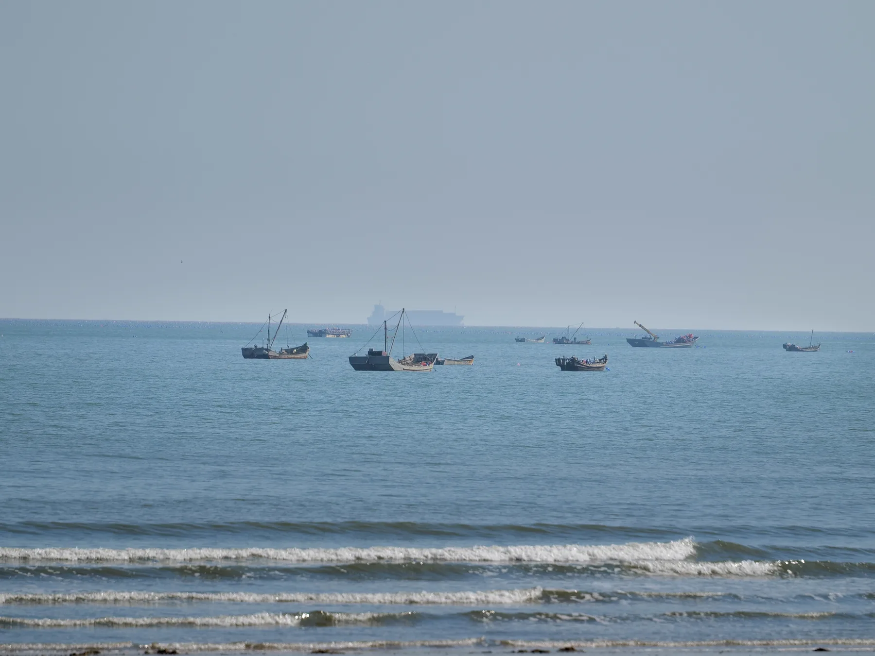 Small fishing boats scattered across a calm blue sea